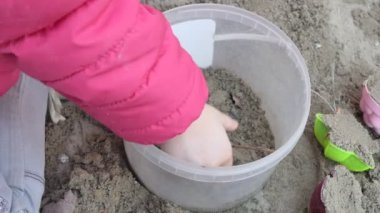 Yavrum. Kumda oyuncaklarla oynayan bir çocuğun elleri. Yakın çekim..