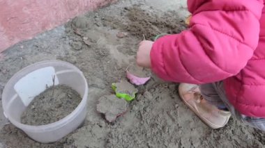 Yavrum. Kumda oyuncaklarla oynayan bir çocuğun elleri. Yakın çekim..