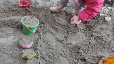 Yavrum. Kumda oyuncaklarla oynayan bir çocuğun elleri. Yakın çekim..