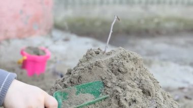 Çocuklar işte. Kumda oynayan bir çocuğun elleri. Yakın çekim..