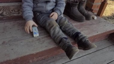 Yavrum. Bir çocuk oyuncak bir ambulans arabasıyla evin merdivenlerinde oturuyor. Yakın çekim..