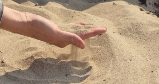 把沙子交出来一个女人在沙滩上揉搓沙子 然后用手指把沙子倒出来 — 图库视频影像