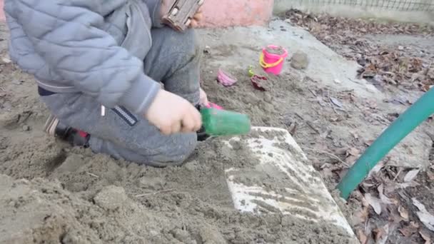 一个在沙滩上玩玩具的孩子的手包扎 — 图库视频影像