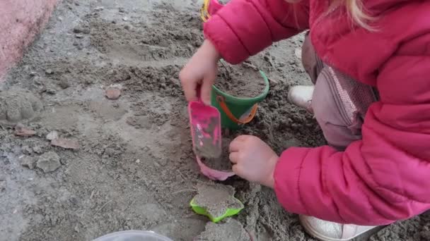 一个在沙滩上玩玩具的孩子的手包扎 — 图库视频影像