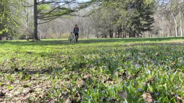 Kendini Soyutlama Tıbbi Maske Takan Bir Kadın Bisikletini Çiçeklerle Ağaçlar — Stok video