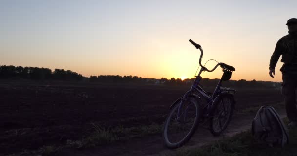 Fahrrad Ein Mann Mit Rucksack Steigt Bei Sonnenuntergang Auf Ein — Stockvideo