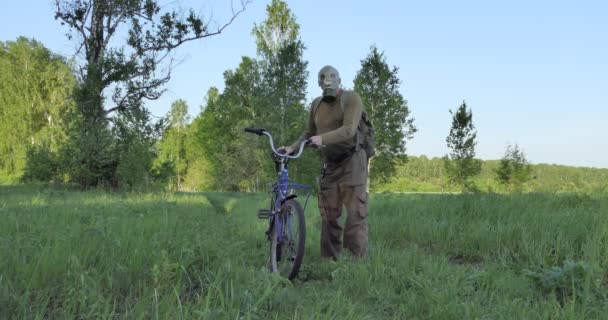 黙示録 黙示録 隔離だ ウイルスの流行の間の人はガスマスクの森の道の自転車に乗る — ストック動画