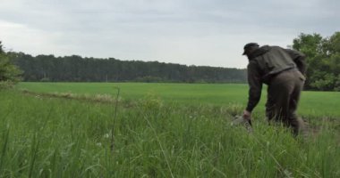 Koşmak. Bir adam kaçarken sırt çantasını takarak bir tarla yolunda koşuyor..