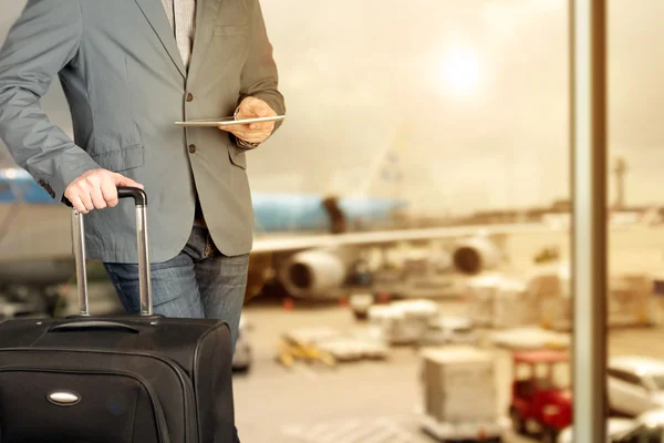 Giovane uomo d'affari che utilizza tablet digitale con bagagli in aeroporto — Foto Stock