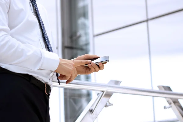 Affärsman hålla och använda den mobila smarta telefonen på kontoret — Stockfoto