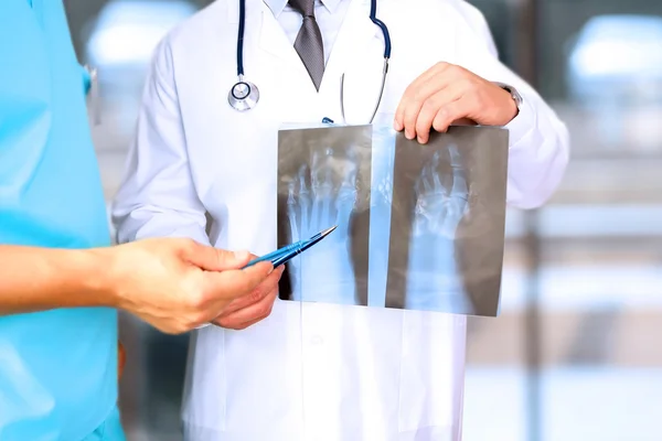 Hälso-och sjukvård, medicinska och radiologiska koncept - manliga läkare tittar på röntgen av foten — Stockfoto