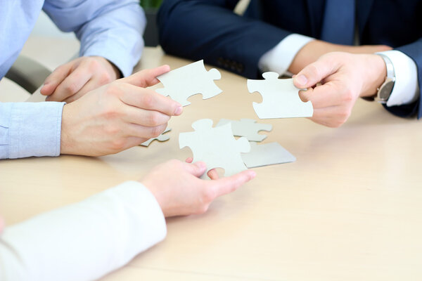 Крупный план бизнесменов, соединяющих головоломку
