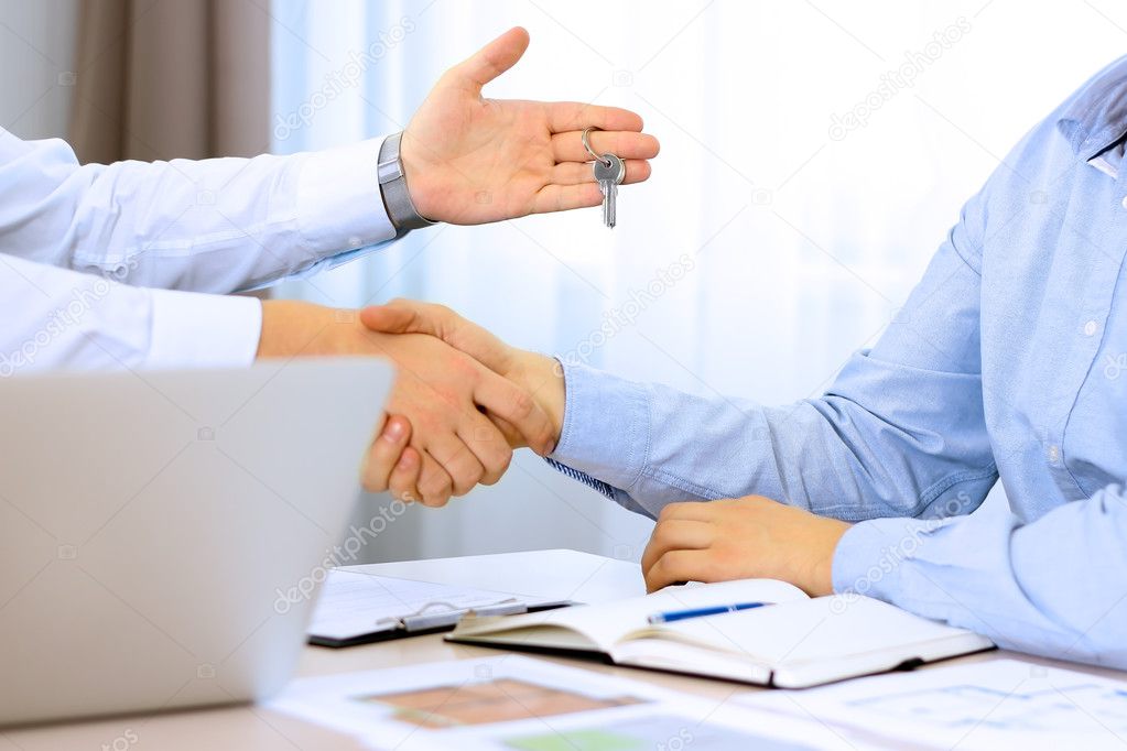Real-estate agent signing a contract. Handshake between two business people