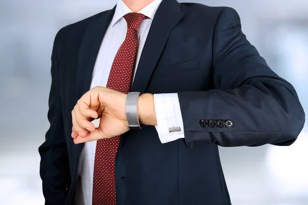 Uomo d'affari controllando il tempo sul suo orologio in ufficio — Foto Stock