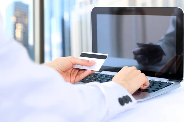 Zakenvrouw invoeren van gegevens van een credit card. Online winkelen op het internet met behulp van een laptop — Stockfoto
