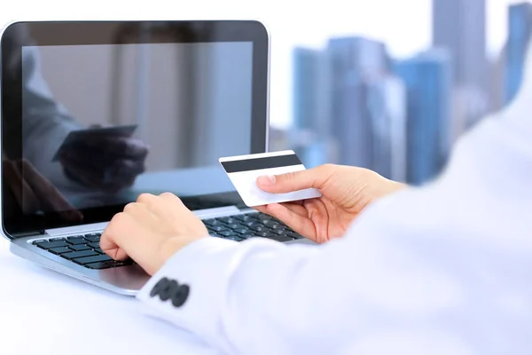 Bir kredi kartı veri girme işkadını. Bir dizüstü bilgisayar kullanarak internette on-line alışveriş