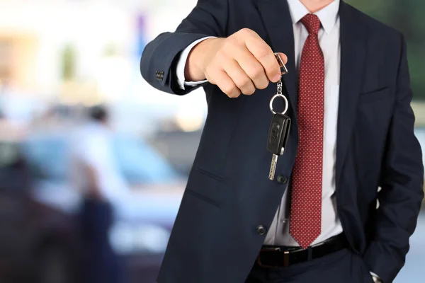 Un exitoso hombre de negocios ofreciendo una llave de auto. Primer plano de la mano del conductor que muestra la llave —  Fotos de Stock