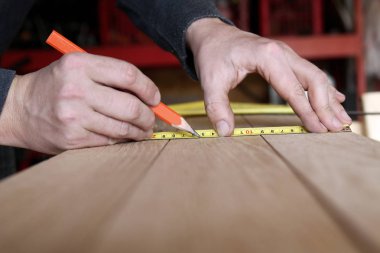 İnşaat işçisi kullanarak şerit metre ve kalem