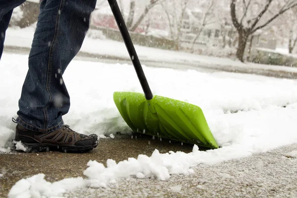 Człowiek łopatą i usuwania śniegu przed jego domem na przedmieściach — Zdjęcie stockowe