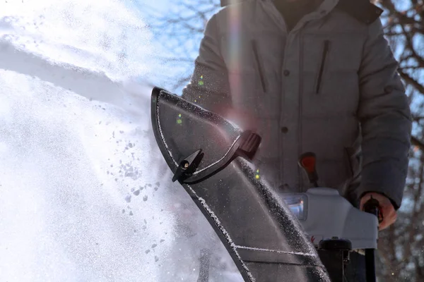 一个人清理积雪从人行道用吹雪机. — 图库照片