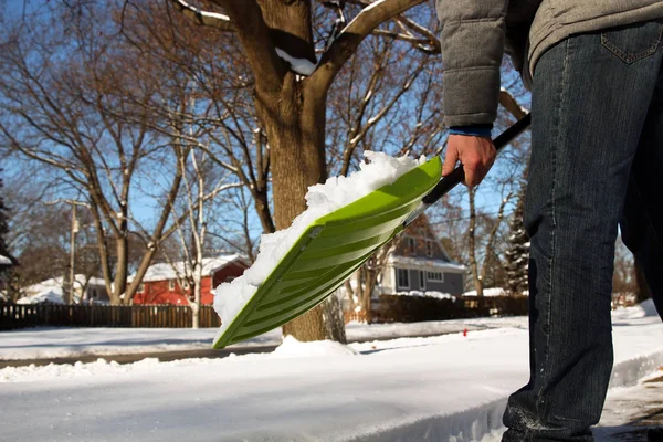 Człowiek łopatą i usuwania śniegu przed jego domem na przedmieściach — Zdjęcie stockowe