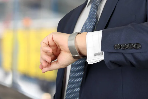Hombre de negocios comprobando el tiempo en su reloj en el aeropuerto — Foto de Stock