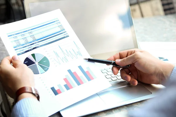 Verksamhet man arbetar och analysera finansiella siffror på ett diagram på en bärbar dator utanför — Stockfoto