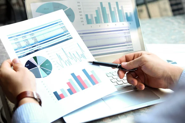 Hombre de negocios que trabaja y analiza las cifras financieras en un gráfico en un ordenador portátil fuera — Foto de Stock