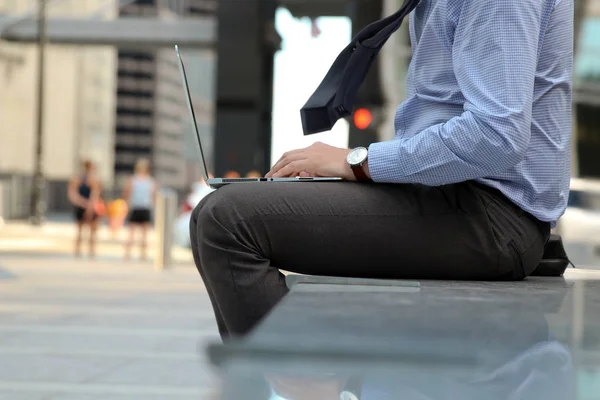 Geschäftsmann beim Arbeiten und Analysieren von Finanzzahlen auf einem Laptop im Freien. — Stockfoto