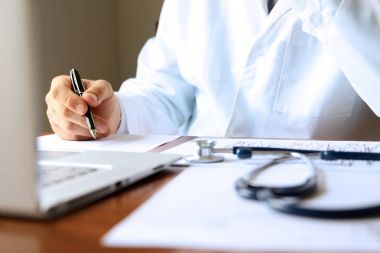 kabine, bir bilgisayarda çalışan doktor