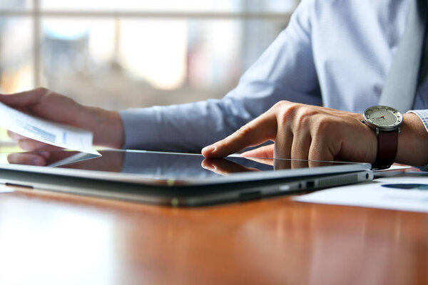 Business man working and analyzing financial figures on a graphs on a laptop 