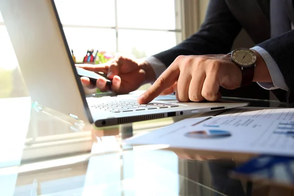 Man met behulp van een moderne mobiele telefoon met een laptop — Stockfoto