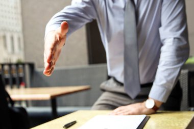 El sıkışma için genişletilmiş açık bir el ile bir iş adamı 