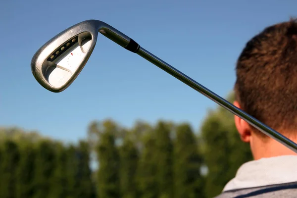 Golf player holding a golf club in golf course — Stock Photo, Image