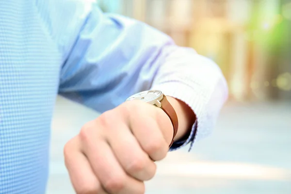 Zakenman tijd op zijn horloge in de buurt van met office controleren — Stockfoto