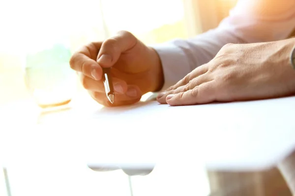Hombre de negocios está firmando un contrato sentado en la oficina —  Fotos de Stock