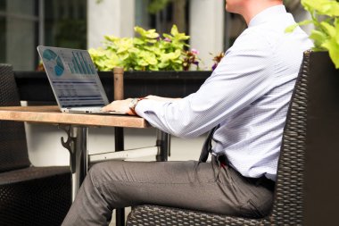 Grafikler dışında bir dizüstü bilgisayar üzerinde çalışan ve mali analiz iş adamı rakamlar