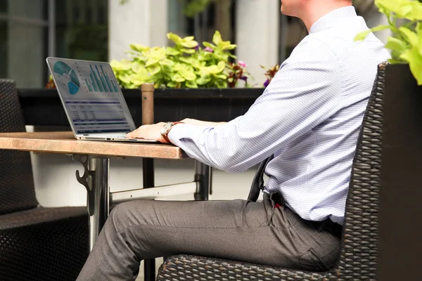 Grafikler dışında bir dizüstü bilgisayar üzerinde çalışan ve mali analiz iş adamı rakamlar