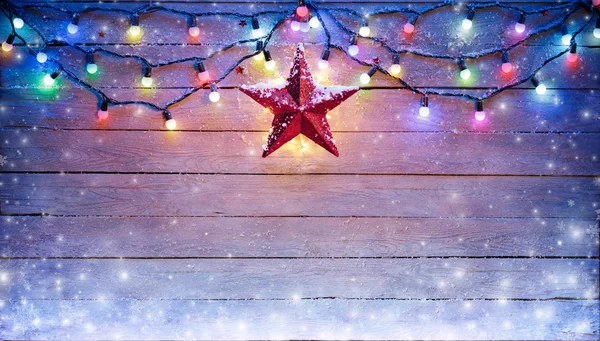 Kerstverlichting en Star opknoping op besneeuwde Plank — Stockfoto