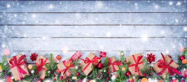 Presentaskar och inredda Fir grenar på snöiga bord - julkort — Stockfoto