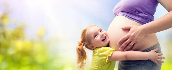 Glückliche Schwester umarmt schwangere Mutter — Stockfoto