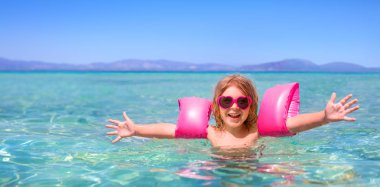 Denizde oynarken mutlu küçük kız