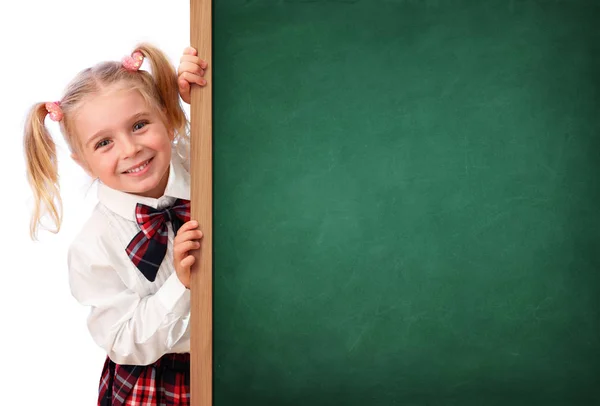 Piccola studentessa che sbircia dietro la lavagna — Foto Stock