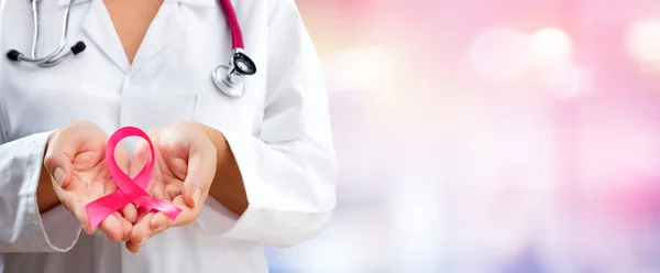 Médico manos sosteniendo cinta de conciencia de cáncer rosa — Foto de Stock