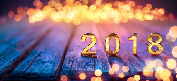 2018 - Feliz Ano Novo - Números dourados na mesa desfocada e luzes Bokeh — Fotografia de Stock