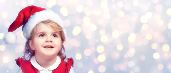 Glückliches und nettes Kind mit Weihnachtsmütze — Stockfoto