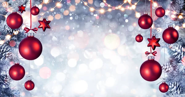 Bolas rojas de Navidad colgando con ramas de abeto nevado y luces de cuerda —  Fotos de Stock