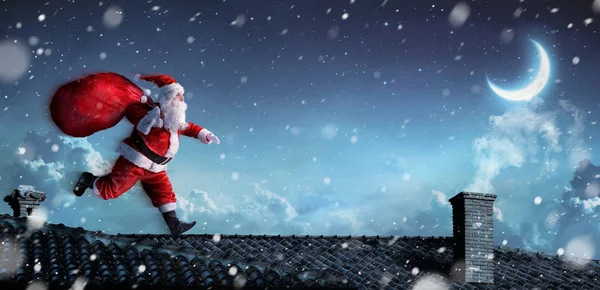 Santa Claus corriendo en los tejados — Foto de Stock