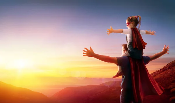 女儿和她的父亲装扮成英雄看日落 — 图库照片
