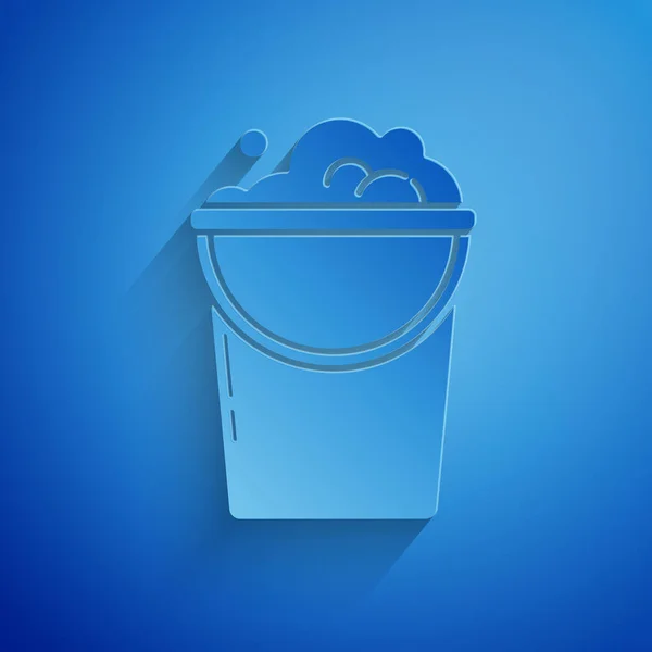 Paper cut Bucket with foam and bubbles icon isolated on blue background. Cleaning service concept. Paper art style. Vector Illustration — Stock Vector